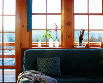 
The low, southern sun warms the living/kitchen area on the upper floor in winter. A thirty-inch roof overhang minimizes summer’s heat. Wood for the floor and beams are from a dismantled naval base; the walls were fashioned from old Sonoma Valley pickling vats.
